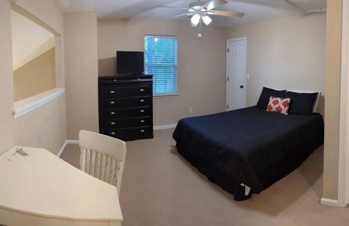 a bedroom with a bed and a table and a chair at Home Away From Home Charlotte in Charlotte