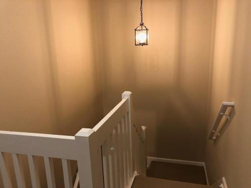 a stairway with a light fixture and a stair case at Home Away From Home Charlotte in Charlotte