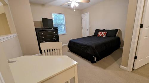 a small bedroom with a bed and a dresser at Home Away From Home Charlotte in Charlotte