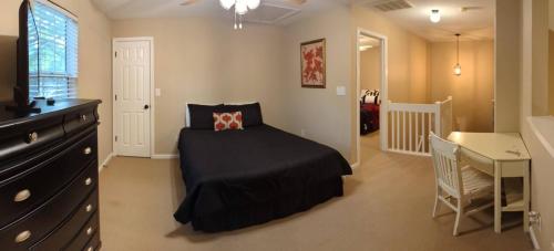 a bedroom with a bed and a dresser and a desk at Home Away From Home Charlotte in Charlotte