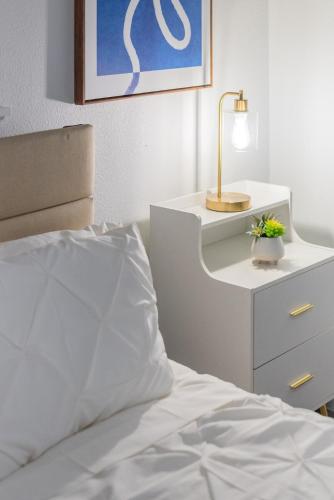 a bedroom with a bed and a dresser with a lamp at Luxurious Home With Hot Tub & Tree Deck By 6flags in San Antonio