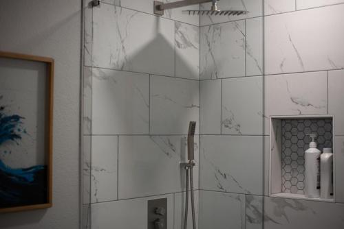 a bathroom with a shower with white marble tiles at Luxurious Home With Hot Tub & Tree Deck By 6flags in San Antonio