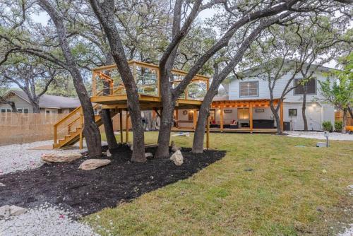 a tree house with a deck between two trees at Luxurious Home With Hot Tub & Tree Deck By 6flags in San Antonio