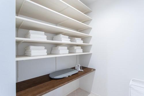 a walk in closet with white shelves at Mova Villa Ozu in Ozu