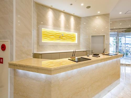 a kitchen with a counter with a painting on the wall at Bande Hotel Tenpozan Higashi in Osaka