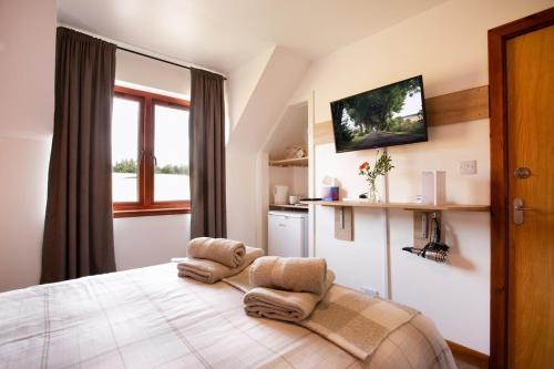 a bedroom with a bed with two chairs on it at Beechwood Lodge in Alness