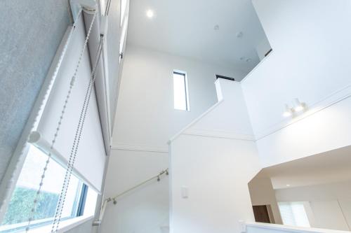 a white staircase in a house with a window at Mova Villa Haramizu in Kikuchi