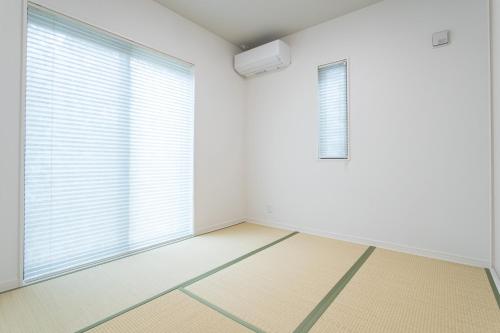 an empty room with a window with blinds at Mova Villa Haramizu in Kikuchi