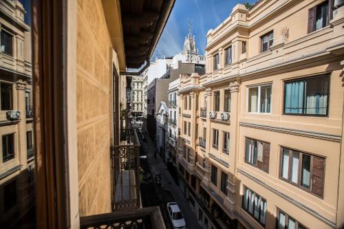 Elle offre une vue sur une rue de la ville depuis sa fenêtre. dans l'établissement Apartamentos Caballero de Gracia, à Madrid