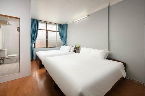 a large white bed in a room with a bathroom at The La Renta Hotel & Spa in Hanoi