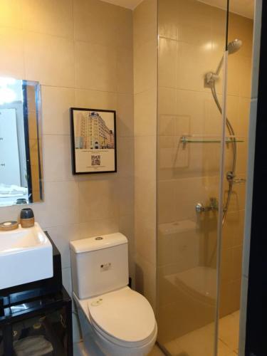 a bathroom with a shower and a toilet and a sink at Saint Honore Executive: 6 guests, 5 beds, 2 bedrooms, 2 bathrms in Iloilo City