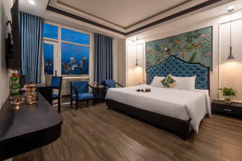 a hotel room with a large bed and a desk at Elites Hotel in Danang