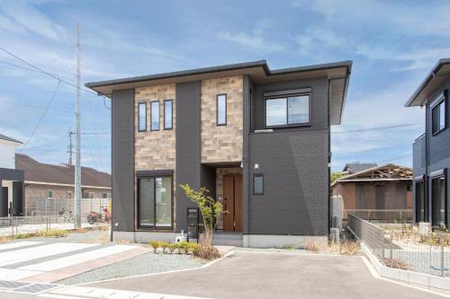 a contemporary house with a black facade at Mova Villa Okino in Kikuyo