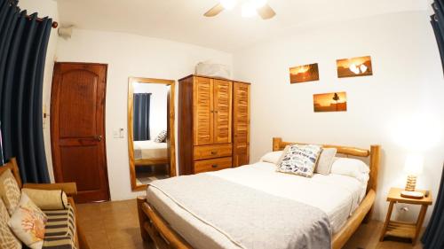 a bedroom with a bed and a dresser and a mirror at Villas Welcome to Heaven in Carrillo