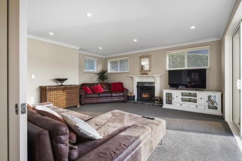 a living room with a couch and a tv at Sanctuary At The Bay - Diamond Harbour Retreat in  Lyttelton