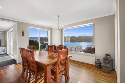 a dining room with a table and chairs and a large window at Sanctuary At The Bay - Diamond Harbour Retreat in  Lyttelton