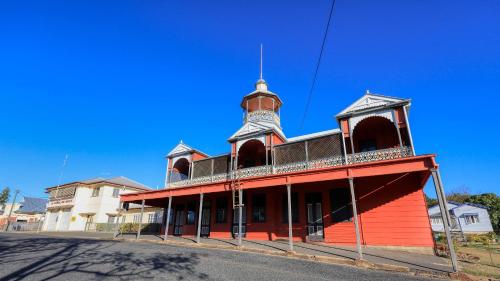 a red building with a tower on top of it at Silver Wattle Cabins in Mount Morgan