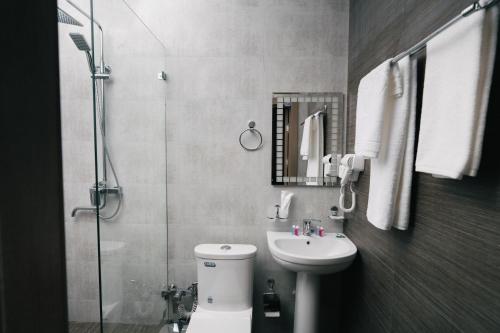 a bathroom with a toilet and a sink and a shower at Grand Castle Hotel in Urganch
