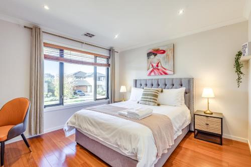 a bedroom with a large bed and a window at StayAU Magnificent Lakefront Villa Stunning Views in Point Cook