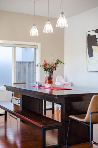 a dining room table with a vase of flowers on it at StayAU Magnificent Lakefront Villa Stunning Views in Point Cook