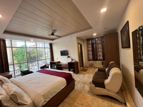 a bedroom with a bed and a couch and a desk at Hotel mauji's legacy in Allahābād