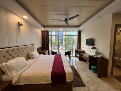 a bedroom with a bed and a desk and a window at Hotel mauji's legacy in Allahābād