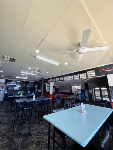 a dining room with tables and chairs and a ceiling fan at The Shamrock Hotel Balranald in Balranald