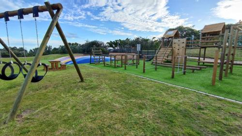 a park with a playground with a slide and swings at Pinnacle Point 2-bedroom self-catering apartment in Mossel Bay