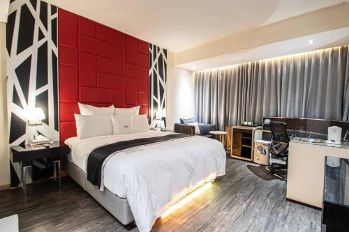 a bedroom with a large bed with a red wall at 168 Motel-Hsinchu in Hsinchu City