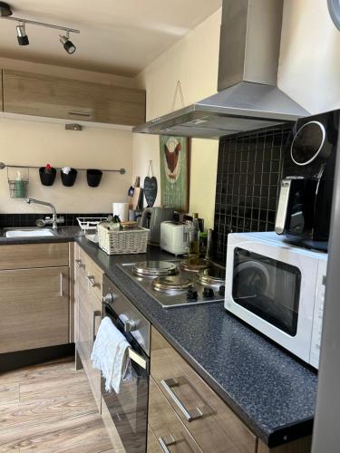 a kitchen with a microwave and a stove top oven at The coach house in Grimston