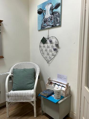 a room with a chair and a heart hanging on the wall at The coach house in Grimston