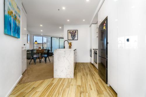 a hallway with a kitchen and a dining room at Contemporary 2BR Retreat in the Heart of Civic - Hosted by Canstay in Canberra
