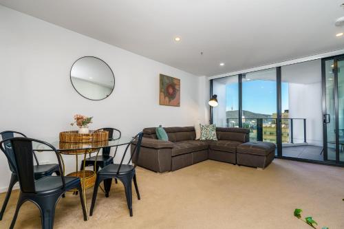 a living room with a couch and a table and chairs at Contemporary 2BR Retreat in the Heart of Civic - Hosted by Canstay in Canberra