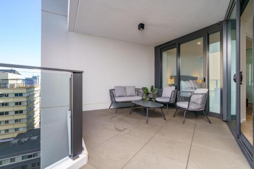 a balcony with chairs and a table on a building at Contemporary 2BR Retreat in the Heart of Civic - Hosted by Canstay in Canberra