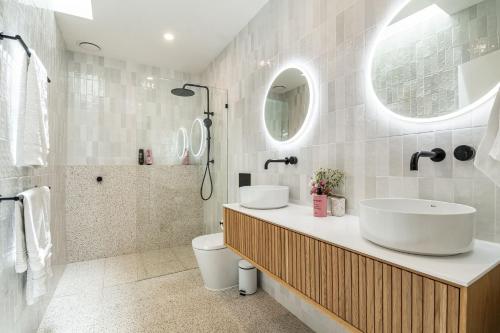 a bathroom with a sink and a toilet and a shower at Frangipani Cottage - Belle Escapes Byron Bay | Winter Escape Deal | Stay Longer & Save | 1 June – 31 August in Byron Bay