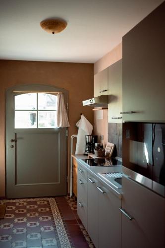 a kitchen with a stove and a window and a door at Thomashof Klein-Mutz in Zehdenick