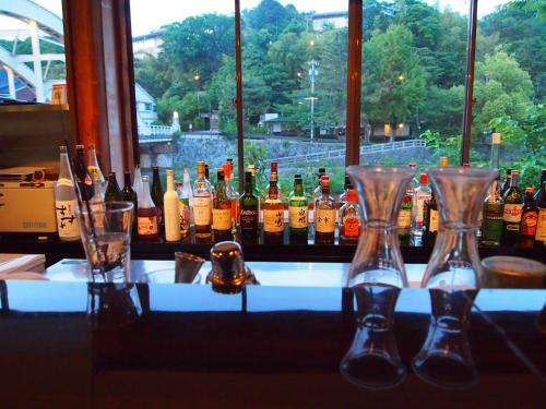 a group of bottles and glasses sitting on a bar at ひがし茶屋街らしく金沢 Hotel Rashiku kanazawa in Kanazawa