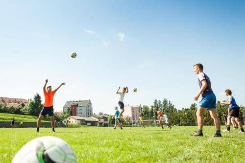 a group of people playing soccer on a field at Youth Hostel Proteus Postojna in Postojna