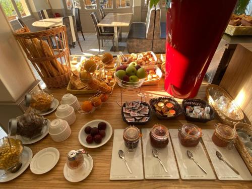 a table topped with plates and bowls of food at KYRIAD ORANGE Centre Ville - HOTEL & RESTAURANT & BAR - La Galerie d'Art des Princes - Provence Alpes Côte d'Azur - France - Proche A7-A9 - exit21- Châteauneuf-du-Pape Avignon Bollene Nimes - 24h-24h in Orange
