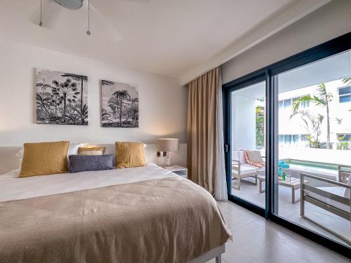 une chambre avec un grand lit et un balcon dans l'établissement Beach Homes Punta Cana, à Punta Cana