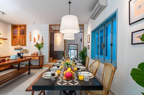 a dining room with a long table and chairs at Villa Nautica By The Beach - Vesta Collections in Hoi An