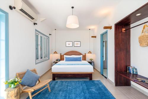 a bedroom with a bed and a blue rug at Villa Nautica By The Beach - Vesta Collections in Hoi An
