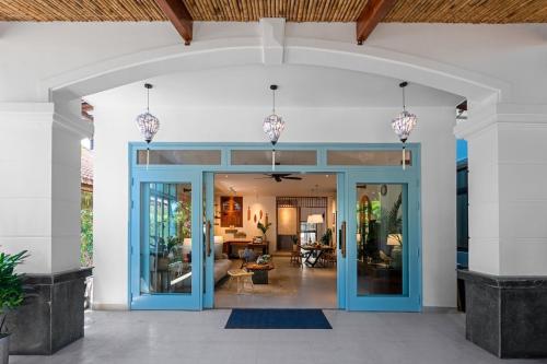 an open lobby with blue doors and a living room at Villa Nautica By The Beach - Vesta Collections in Hoi An