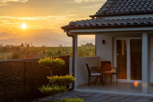 a house with a balcony with a table and a sunset at Carolina Apartment's in Zilotí