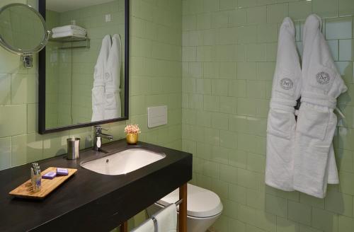 a bathroom with a sink and a toilet and a mirror at Abrigo da Montanha Hotel Rural in Sabugueiro