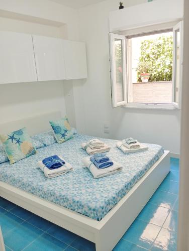 ein Schlafzimmer mit einem Bett mit Handtüchern und einem Fenster in der Unterkunft IL RE TRITONE in Agropoli