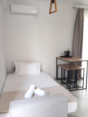 a bedroom with a white bed and a table at Three Charites Resort in Gialova