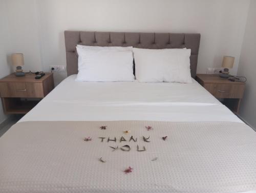 a bed with a thank you sign on it at Three Charites Resort in Gialova