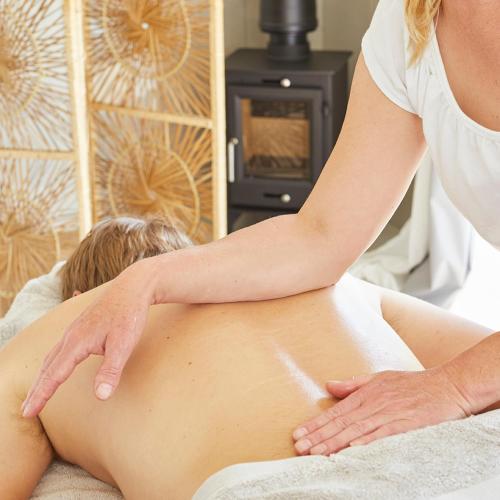 a woman getting a massage from a therapist at Puckaster Cove Cabin in Niton