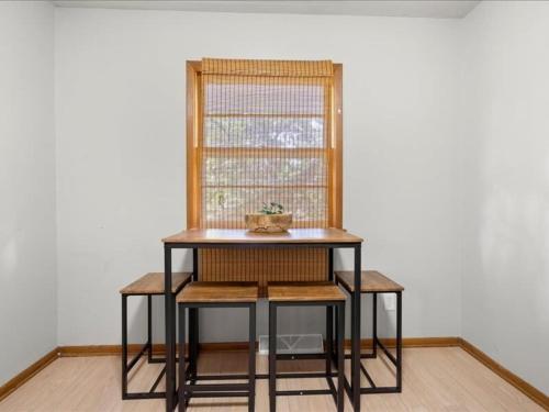 a table and chairs in a room with a window at Charming Family Friendly 3br Duplex Close To Drake in Des Moines
